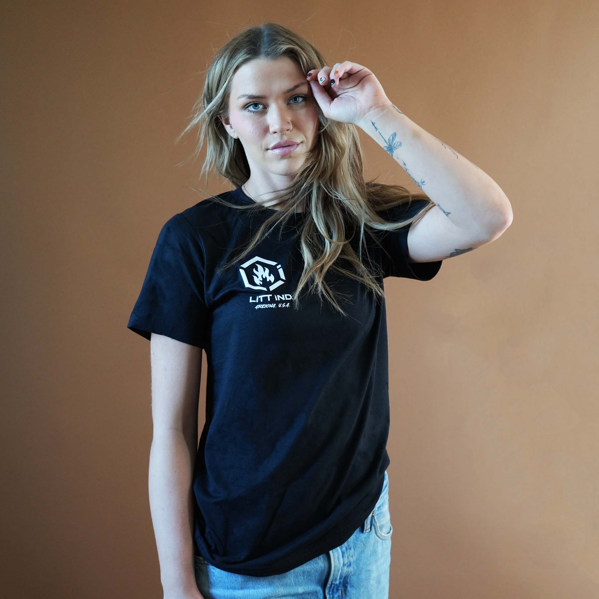 Person wearing a black t-shirt with a logo against a brown background